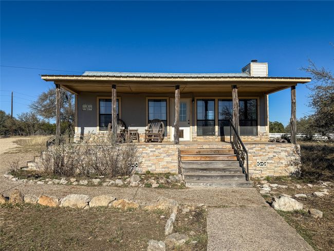 View of front facade featuring a chimney, stucco siding, and covered porch | Image 7
