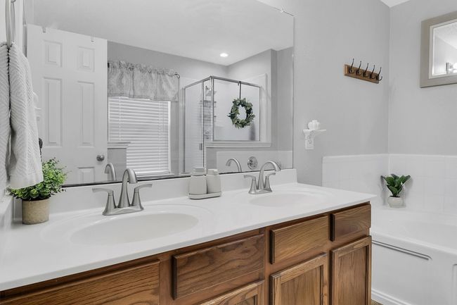 Full bathroom with a sink, double vanity, a bath, and a shower stall | Image 9