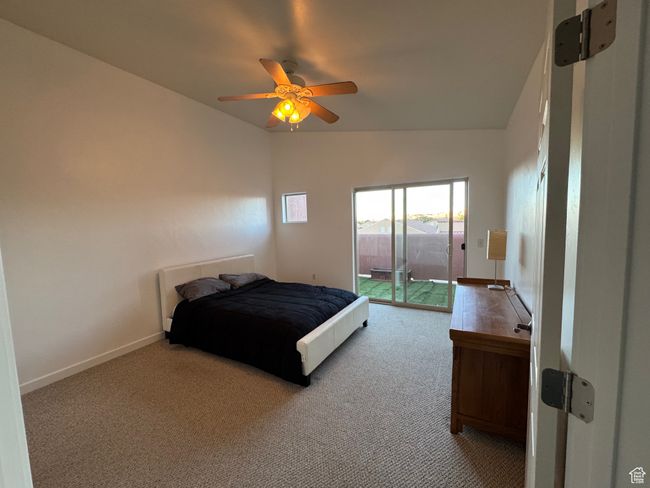 Carpeted bedroom featuring ceiling fan, lofted ceiling, and access to outside | Image 5