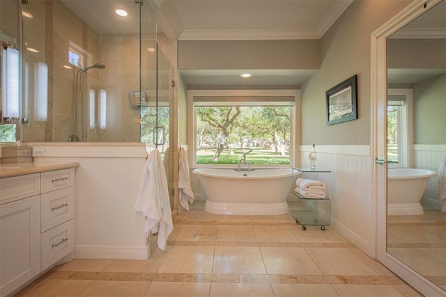 Full bath with crown molding, inlaid floor details, vanity, tiled shower, and wainscoting | Image 20