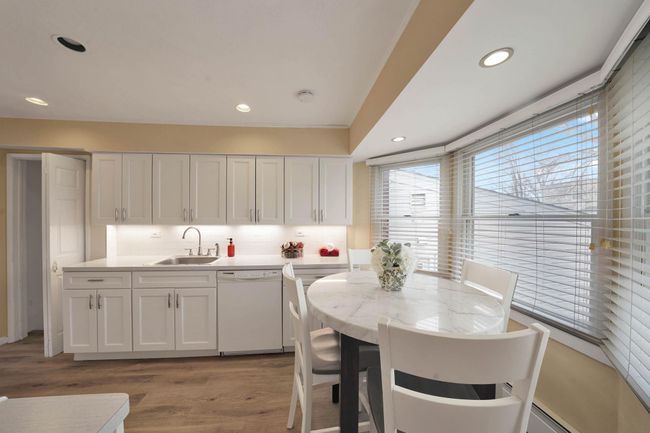 Kitchen with sink, white cabinets, dishwasher, light hardwood / wood-style floors, and tasteful backsplash | Image 11