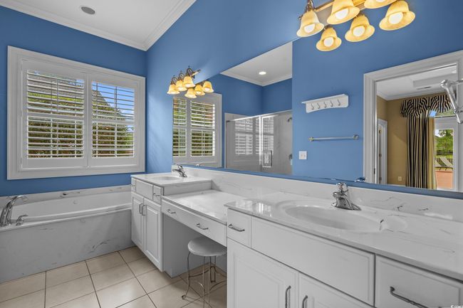 Bathroom with double vanity, a bath, tile patterned flooring, a shower stall, and crown molding | Image 21