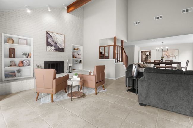 Living room featuring high vaulted ceiling, stairs, light tile patterned flooring, a brick fireplace, and beam ceiling | Image 27