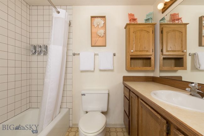 Full bathroom with tile patterned flooring, shower / bath combination with curtain, vanity, and toilet | Image 17