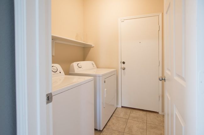 Laundry area with separate washer and dryer and light tile patterned floors | Image 32