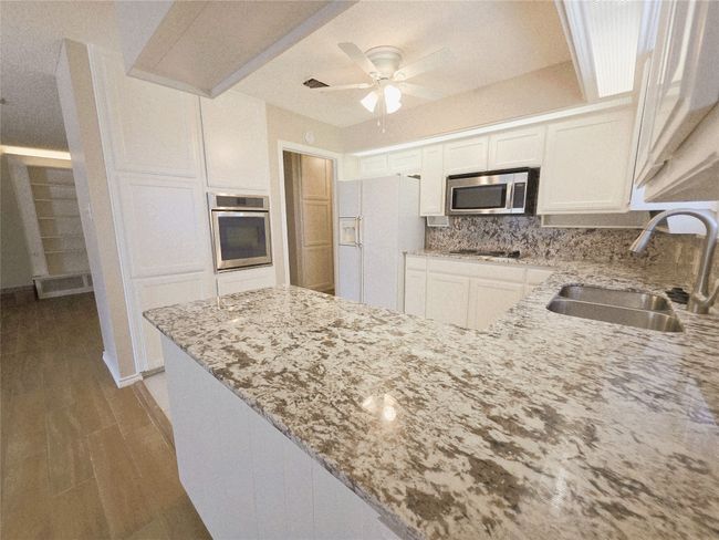 Kitchen featuring dishwasher, a sink, tasteful backsplash, a peninsula, and a ceiling fan | Image 15