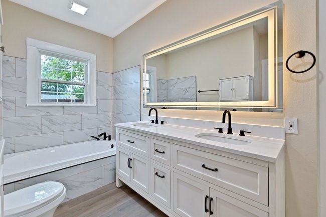 Bathroom with wood finished floors, double vanity, tiled tub, and a sink | Image 22