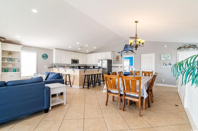 Dining space with a chandelier, light tile patterned floors, lofted ceiling, recessed lighting, and baseboards | Image 22