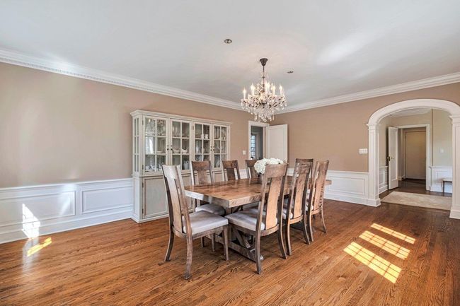 Formal dining room with arched walkways, a decorative wall, chandelier, crown molding; perfect for dinner parties! | Image 4