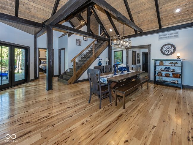 dining room with high vaulted ceiling, wood ceiling with exposed beams, a chandelier, stairway, and light wood-style floors | Image 12
