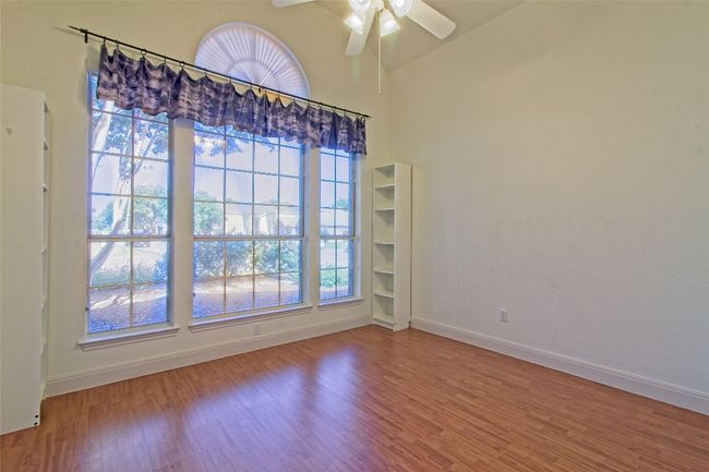 Spare room with wood finished floors, a ceiling fan, and lofted ceiling | Image 23
