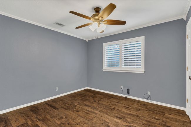 Spare room featuring ceiling fan, dark wood finished floors, and crown molding | Image 21