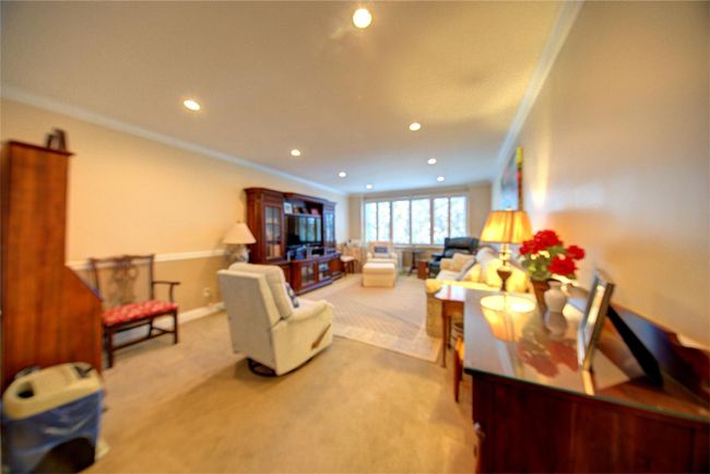 Carpeted living room featuring baseboards, ornamental molding, and recessed lighting | Image 11