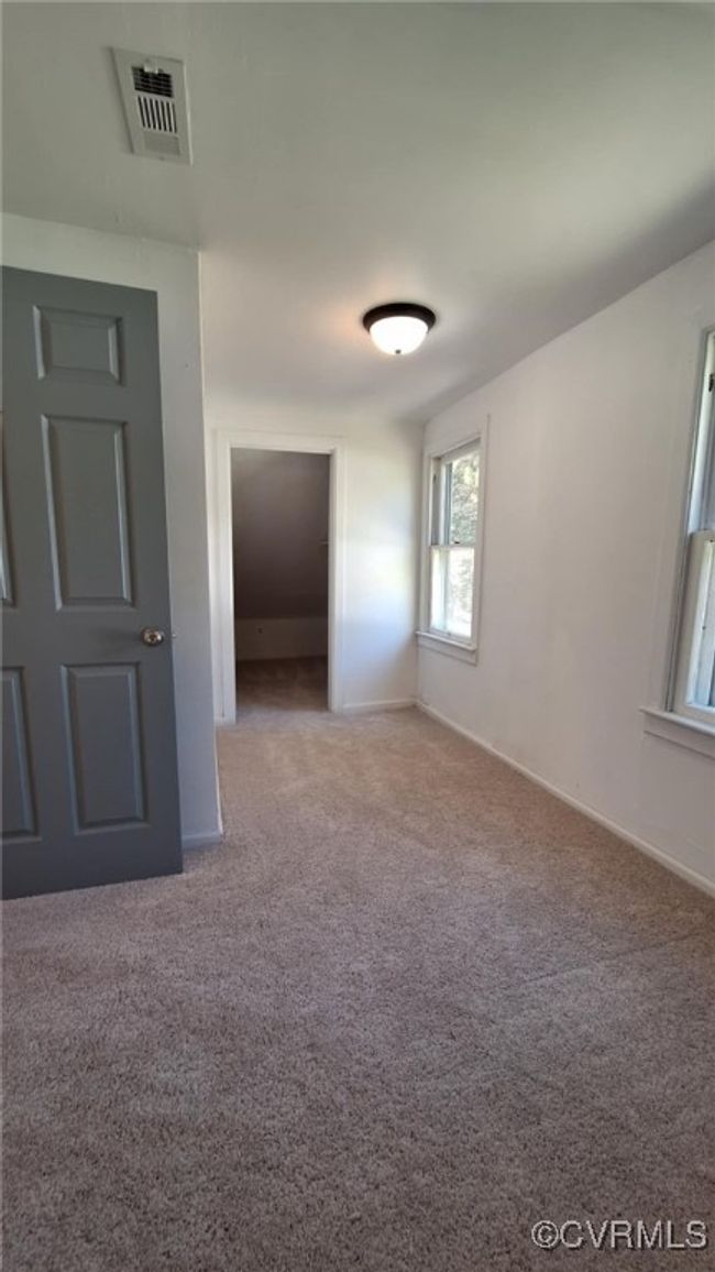 Empty room featuring visible vents, baseboards, and light colored carpet | Image 29