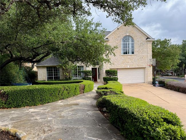 View of front of house featuring concrete driveway, stone siding, and a garage | Image 35