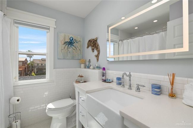 Bathroom with tile walls, vanity, toilet, and tile patterned floors | Image 12