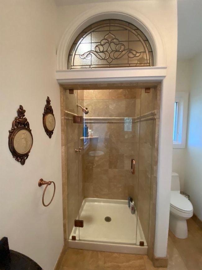 Downstairs third bath has beautiful stained glass over shower. | Image 45