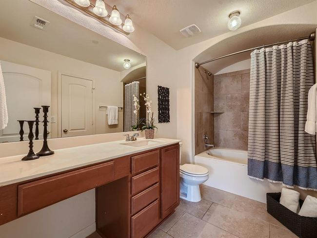 Full bath featuring tile patterned flooring, vanity, toilet, and shower / bathtub combination with curtain | Image 8