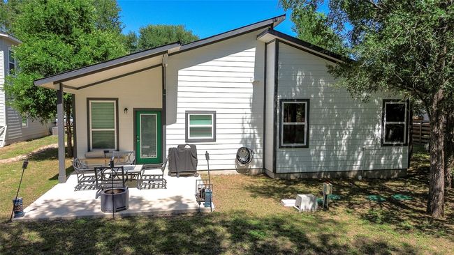 Tree-shaded backyard view of the house. | Image 5