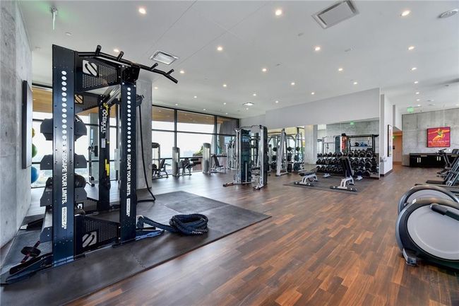 Gym featuring wood finished floors and floor to ceiling windows | Image 16