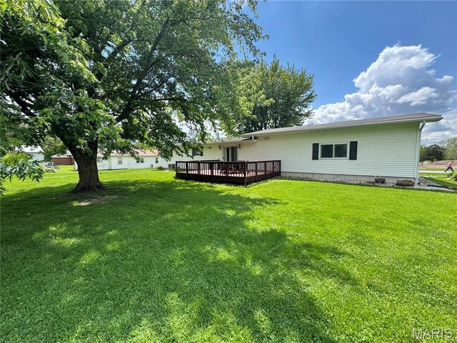 View of green lawn featuring a wooden deck | Image 7