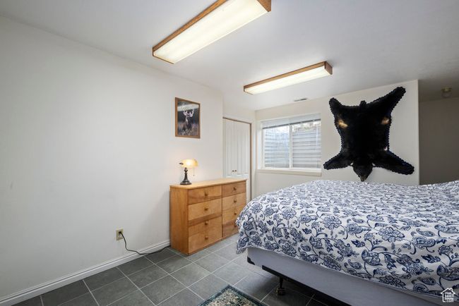Bedroom with dark tile patterned floors, baseboards, a closet, and visible vents | Image 41