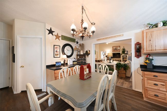 Dining area with a chandelier and dark wood-type flooring | Image 26