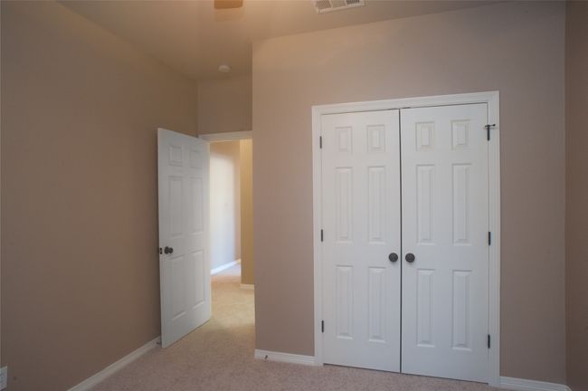 Unfurnished bedroom featuring baseboards, light carpet, and a closet | Image 16