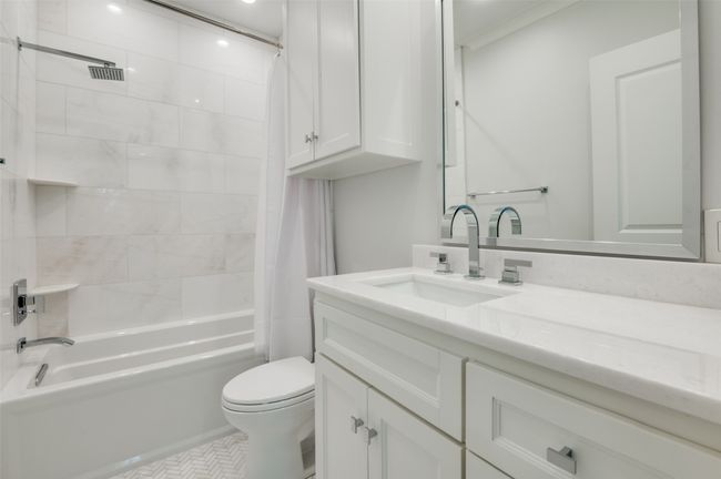 Bathroom featuring toilet, vanity, tile patterned flooring, and shower / tub combo with curtain | Image 21