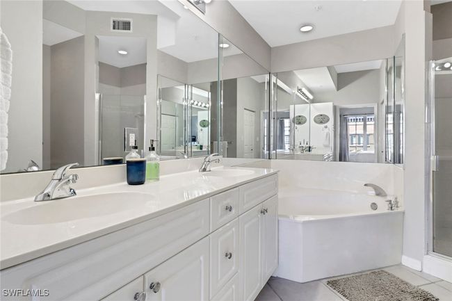 Full bath featuring a bath, double vanity, a shower stall, and tile patterned​​‌​​​​‌​​‌‌​‌‌​​​‌‌​​‌‌​‌​​​​​‌ flooring | Image 8