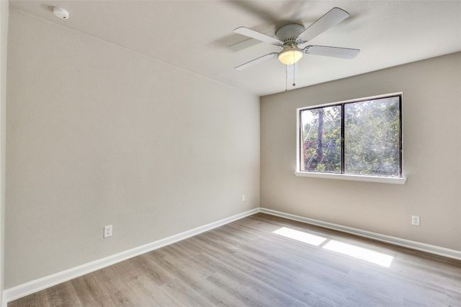 Spacious primary bedroom with updated flooring and ceiling fan. | Image 18