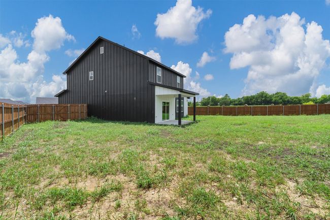Back of property with a fenced backyard and board and batten siding | Image 39