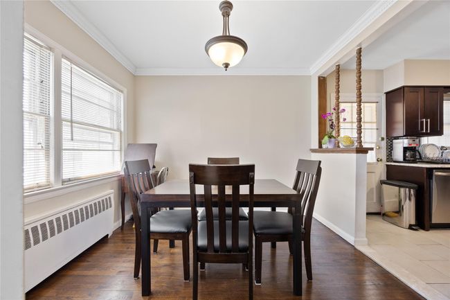 Dining room featuring ornamental molding, radiator heating unit, a wealth of natural light, and wood finished floors | Image 6