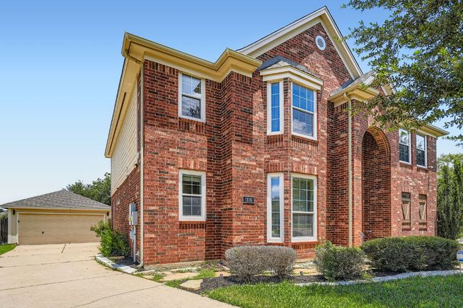 View of front of home featuring brick siding, an outbuilding, and a garage | Image 36