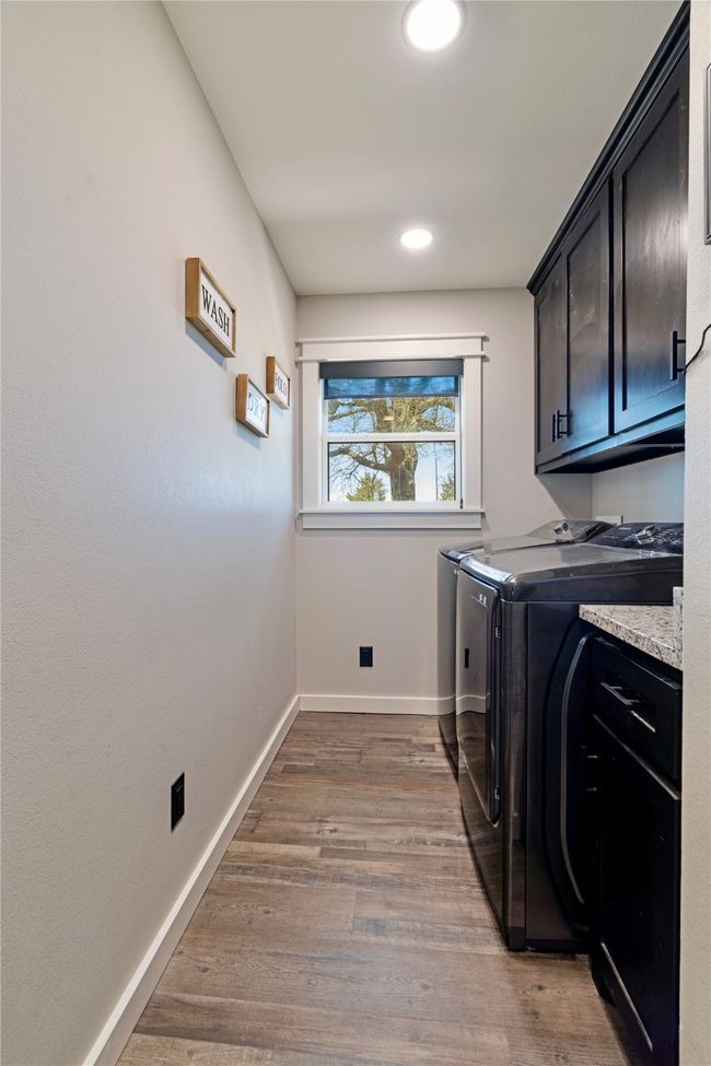 Laundry room featuring washing machine and clothes dryer, baseboards, recessed lighting, light wood-style floors, and cabinet space | Image 17