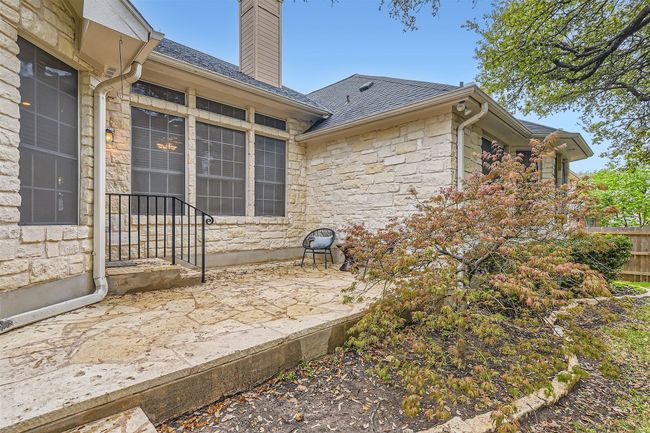 Limestone patio, with decorative black railing leading from pedestrian door off breakfast dining | Image 26