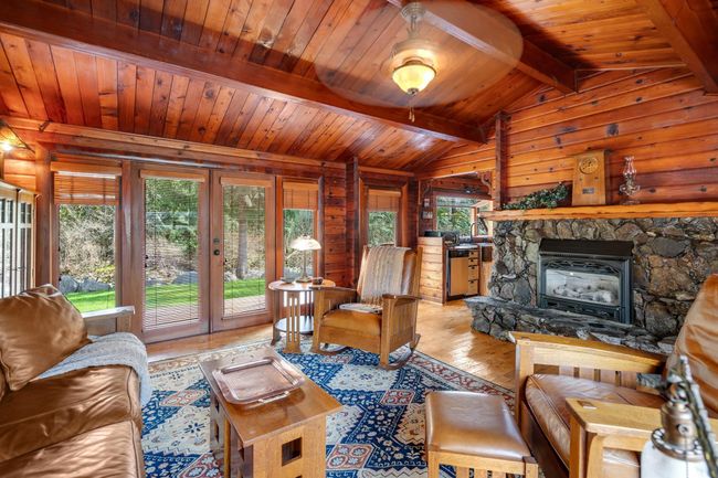 Living room featuring light wood finished floors, wood ceiling, and wooden walls | Image 8