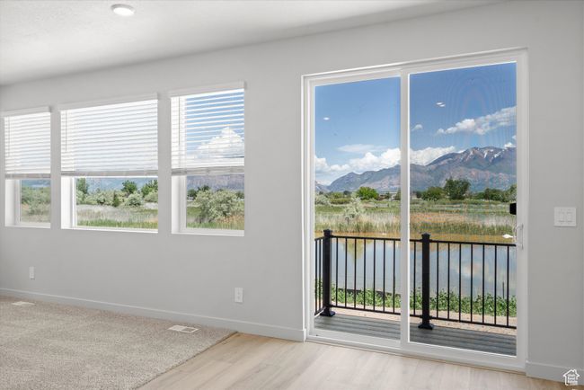 Spare room featuring a water and mountain view and wood finished floors | Image 19