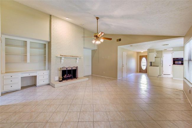 Family room with vaulted ceilings, built-ins, and a gas-log fireplace! | Image 5