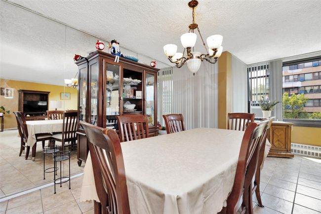 Dining space featuring a chandelier, light tile patterned floors, cooling unit, and a textured ceiling | Image 5