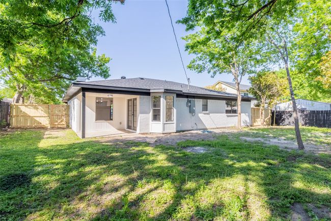 Back of house featuring a fenced backyard, roof with shingles, and a lawn | Image 28