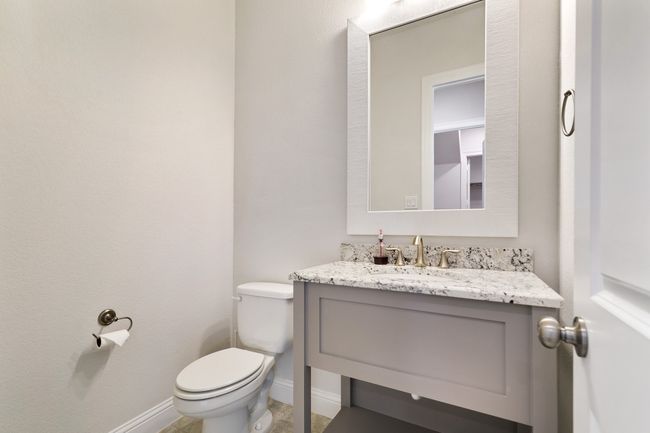 Bathroom featuring baseboards, toilet, and vanity | Image 21