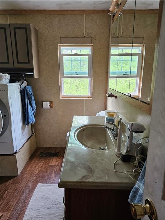 Bathroom with a wealth of natural light, wood finished floors, washer / dryer, and vanity | Image 10