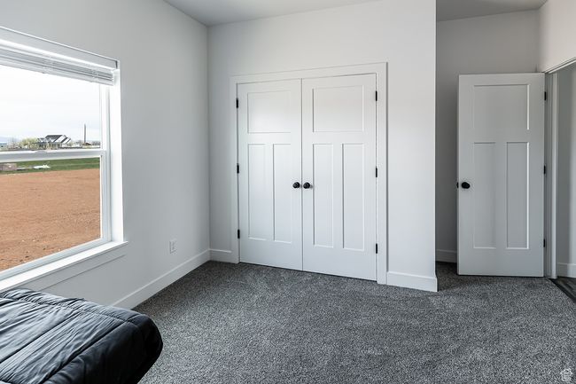 Bedroom featuring dark colored carpet, a closet, and baseboards | Image 27