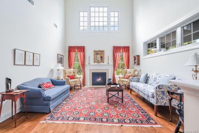 Living room with a towering ceiling, wood-type flooring, and a healthy amount of sunlight | Image 3