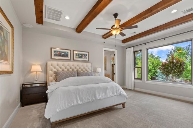 Bedroom featuring baseboards, beamed ceiling, visible vents, and carpet | Image 17