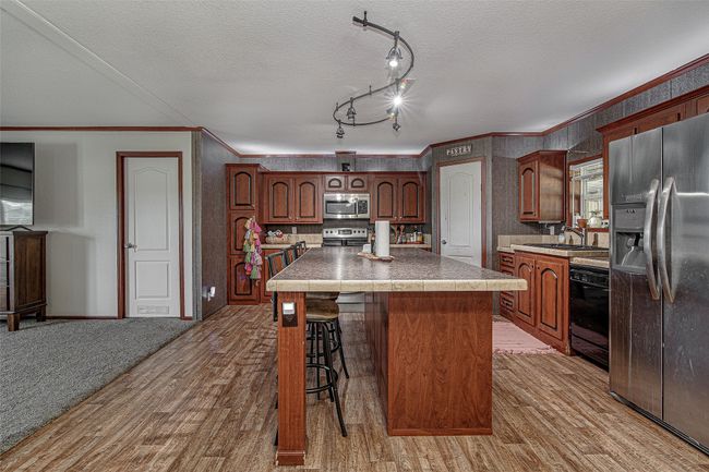 Main house - kitchen with center island, updated appliances, and a breakfast bar | Image 9