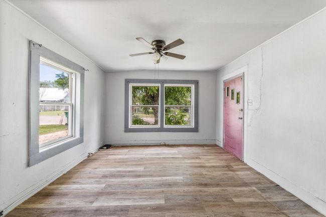 Spare room featuring healthy amount of natural light, ceiling fan, wood finished floors, and baseboards | Image 6
