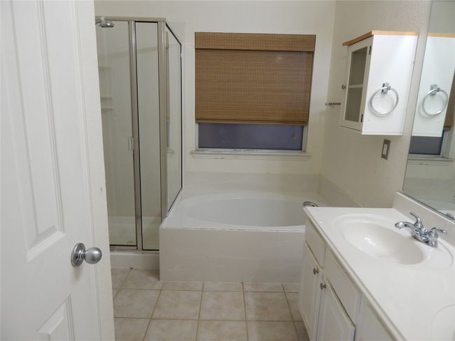 Full bathroom featuring a shower stall, tile patterned flooring, a garden tub, and double vanity | Image 15
