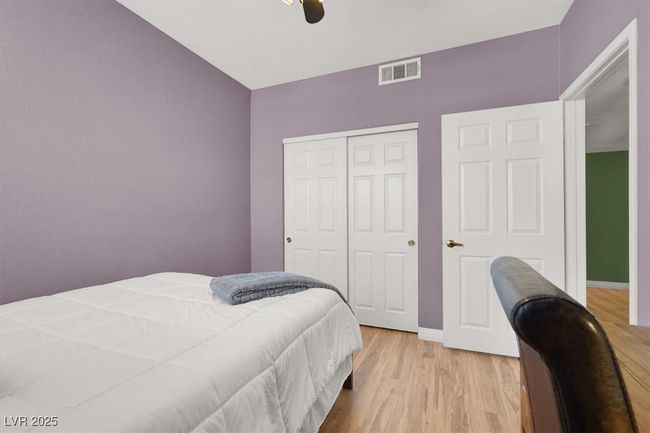 Bedroom with a closet, light wood finished floors, baseboards, visible vents, and a ceiling fan | Image 25